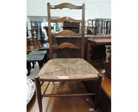 An early 20th century stained frame kitchen chair having ladder back with rush seat and turned legs 