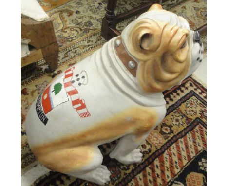 A plastic figure of a bulldog, the emblem of Southampton United Football Club emblazoned upon its back, a child's quarter siz