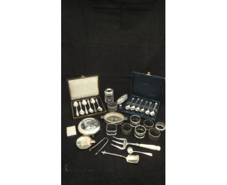 A collection of small silver wares to include two sets of six silver teaspoons, eight various napkin rings, an embossed silve