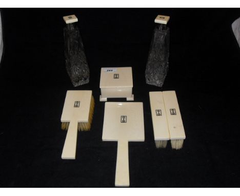 A George V ivory dressing table set of seven pieces comprising three brushes, mirror, dressing table box and two dressing tab