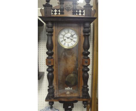 A walnut cased Vienna regulator wall clock with Roman numerals to the enamelled dial