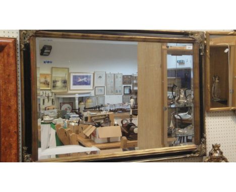 A rectangular wall mirror in a gilt and ebonised effect frame