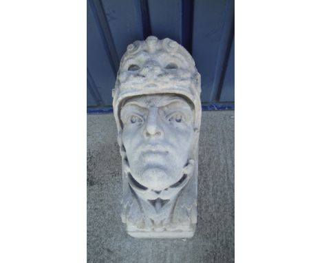 A pair of 19th Century large carved Portland stone corbels each depicting a head with helmet decorated with animal mask emble