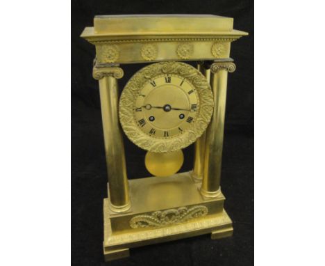 A French Regency period lacquered brass cased mantle clock with Ionic column supports, the eight day movement with circular e