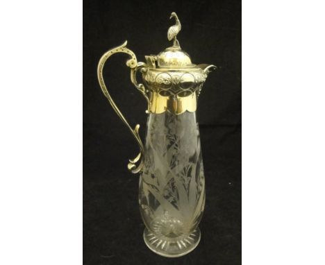 A cut glass and gilt metal mounted claret jug with floral spray decoration, the mounts in the Victorian Gothic style with Emu
