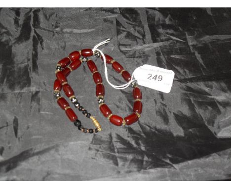 A vintage red amber bead, jet and pique work bead decorated necklace   CONDITION REPORTS  Various scratches, scuffs and marks
