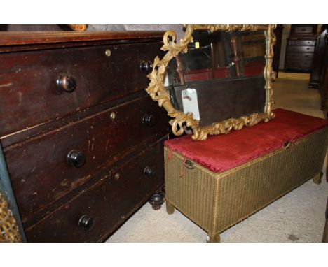 A Victorian stained pine chest of three drawers together with a Lloyd Loom ottoman and a gilt dramed wall mirror