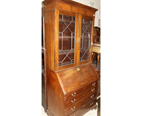 A 19th Century mahogany bureau bookcase, the upper section with two glazed doors enclosing adjustable shelving over a sloping
