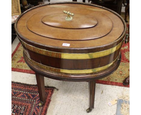 A George III mahogany and brass bound oval wine cooler with twin handles, raised on four square legs to brass caps and castor