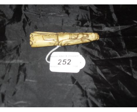 A Chinese carved bone netsuke as a bearded man, a sword in his right hand
