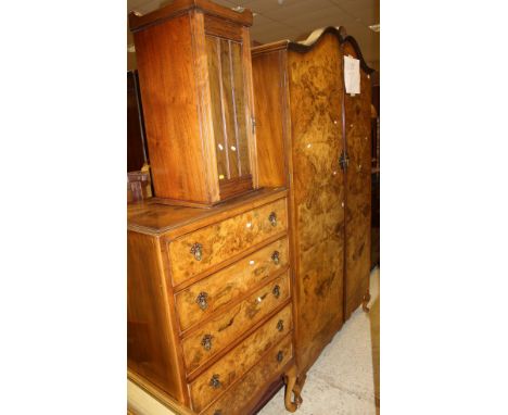 An early 20th Century walnut bedroom suite comprising five drawer chest, double wardrobe and headboard, dressing table with m