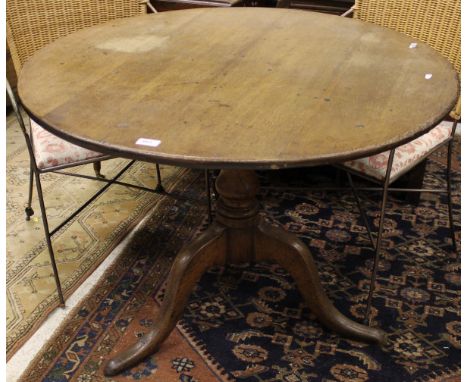 A 19th Century oak tilt top table, the circular top on pedstal support to tripod base