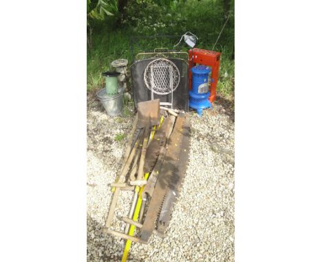 A collection of vintage garden tools to include two man saws, shovels, forks etc., assorted fire guards, greenhouse heaters e