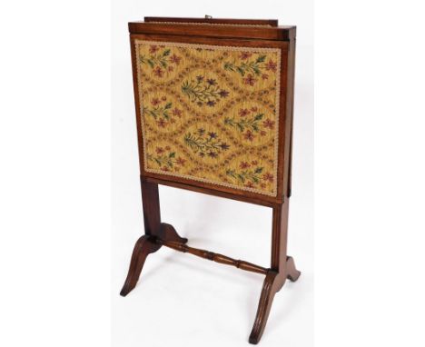 A late 19thC mahogany fire screen, with adjustable top and sides with embroidered front on saber reeded supports, joined by a