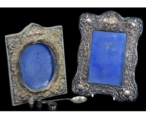 An Edwardian silver photograph frame, of shaped rectangular form, heavily repousse decorated with scrolls and flowers with a 