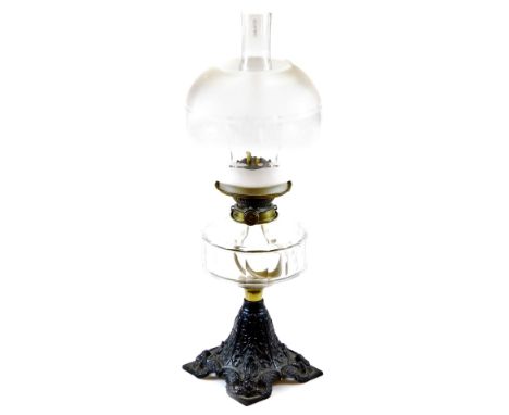 An early 20thC oil lamp, with frosted and clear glass shade, moulded glass reservoir and cast iron base with plain funnel, 58
