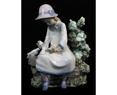 A Nao by Lladro figure, of a girl seated aside dove and shrubs, marked beneath, 23cm high.