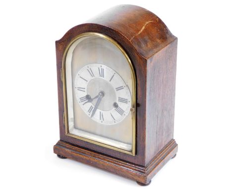 An Edwardian oak mantel clock, in domed case with silvered 11cm diameter chaptering, on compressed orb feet with an eight day