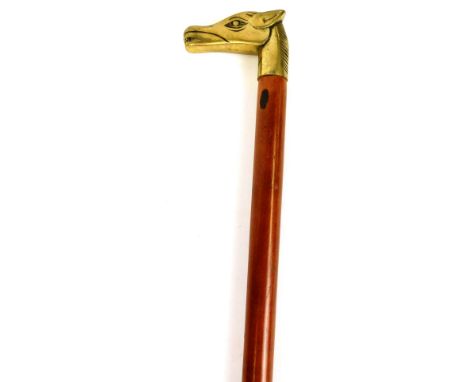 A walking stick with brass horse head top, and plain tapering stem with rubber end, 86cm high.