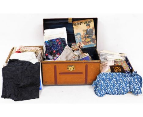 An early 20thC dome topped tin trunk, with raised studding, side handles, 55cm wide, and a quantity of various linen, some wo