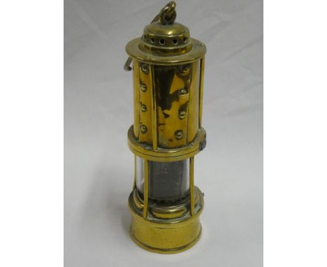 An old brass mining lamp by Thomas &amp; Williams with gauze centre and swing handle
