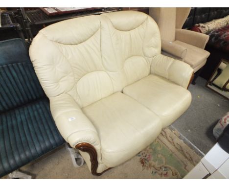A CREAM LEATHER TWO SEATER SOFA
