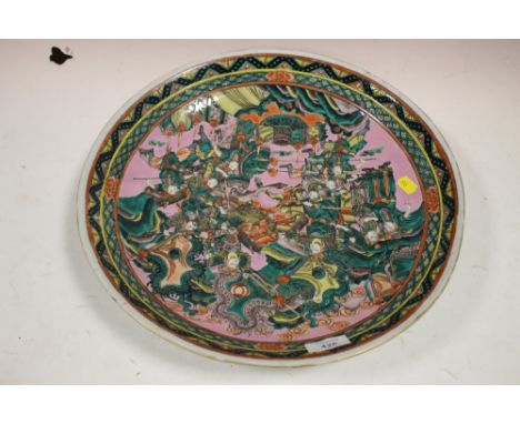 A LARGE ORIENTAL CERAMIC CHARGER FEATURING A BATTLE SCENE S/D