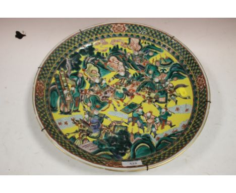 A LARGE ORIENTAL CERAMIC CHARGER FEATURING A BATTLE SCENE