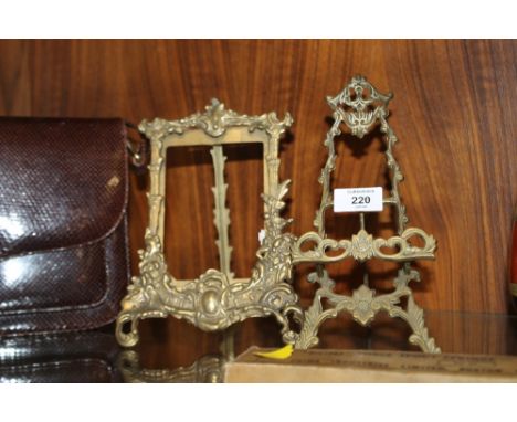 A VINTAGE BRASS PICTURE FRAME AND A SIMILAR PICTURE STAND