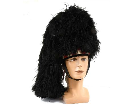 A Highland Piper's Feather Bonnet by Jaffé, of black ostrich feathers, with black, red and white diced woollen hat band, with