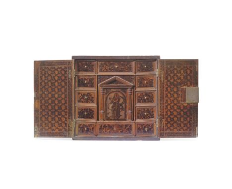 A North Italian carved cypress or cedarwood penwork decorated table cabinet17th century With two panelled doors carved with s