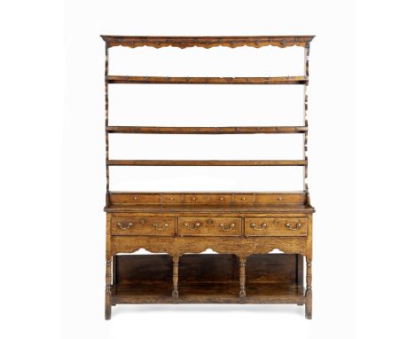 A Welsh 18th century oak dresserThe plate rack with iron hooks above five spice drawers, the base fitted with three short dra
