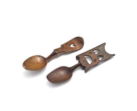 A Welsh 19th century love spoon, together with anotherThe shaped scroll handle pierced with a heart with chip carved surround