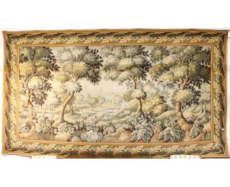 A Verdure Machine Made Tapestry, the field depicting a rural scene enclosed by acanthus leaf borders, 390cm by 225cm