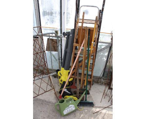 AN ASSORTMENT OF GARDEN TOOLS TO INCLUDE RAKES, LADDERS AND AN ELECTRIC LEAF BLOWER 
