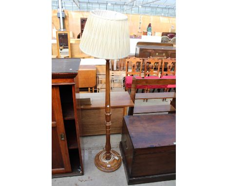 AN OAK STANDARD LAMP WITH TURNED AND FLUTED COLUMN ON ROUND BASE WITH SHADE 