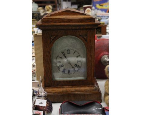 AN EDWARDIAN OAK CASED MANTLE CLOCK WITH PENDULUM, WORKING AT TIME OF CATALOGUING, NO WARRANTY 