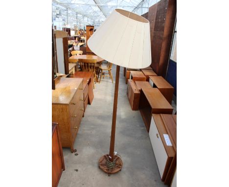 A 20TH CENTURY OAK STANDARD LAMP ON CLOVER LEAF SHAPED BASE WITH TAPERING COLUMN AND SHADE 