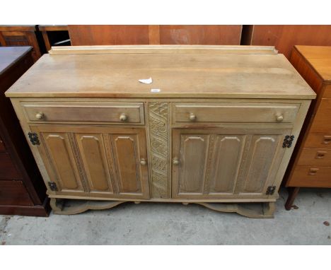 A JACOBEAN STYLE LIGHT OAK SIDEBOARD ON SHAPED BASE, 55" WIDE 