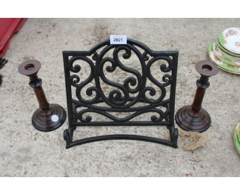A CAST IRON BOOK STAND AND A PAIR OF VINTAGE WOODEN CANDLESTICKS 