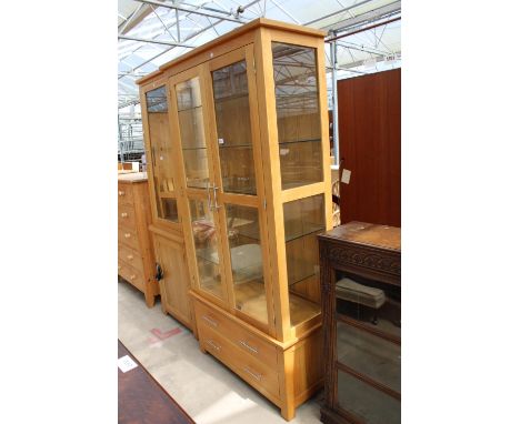 A MODERN LIGHT OAK TWO-DOOR DISPLAY CABINET WITH TWO DRAWERS TO BASE, 35.5" WIDE 