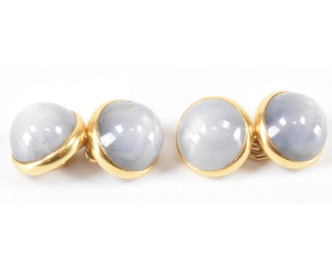 A pair of 18ct gold and star sapphire cufflinks. Each being set with two round star sapphire cabochons in bezel mounts united