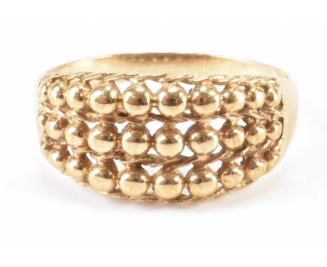A modern hallmarked 9ct gold keeper ring. The ring having three row woven and bead decoration to head on plain gold shoulders