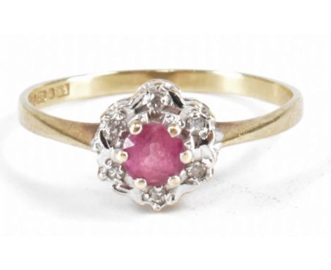 A vintage pink stone and diamond cluster ring. The ring being set with a central round cut pink stone and a halo of round cut