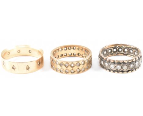 Three vintage gold and white stone eternity rings. Two rings having cross design decoration on a plain gold background and th