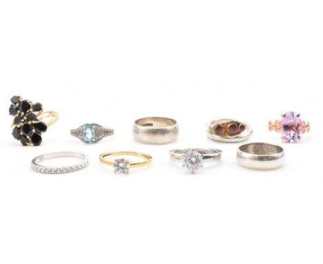 A group of nine silver stone set and band rings. The lot to include a gilt silver and black stone cluster ring, a purple ston