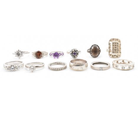 A group of twelve silver stone set rings. The lot to include a white stone eternity ring, a purple stone dress ring, a panel 