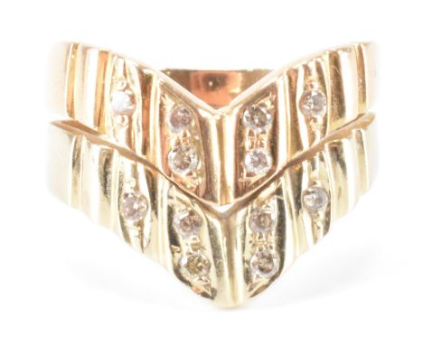 A middle eastern gold and diamond wishbone ring. The two tone gold ring having two reeded bands set with twelve round cut dia