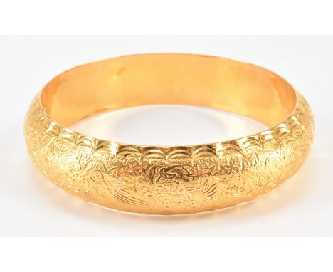 A gold middle eastern bangle bracelet. The bracelet having moulded decoration featuring birds and florals. Arabic marks to in