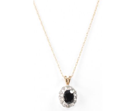 A hallmarked gold sapphire and diamond pendant on a fine link gold chain. The pendant having an oval cut sapphire mounted in 